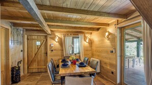 Ein Esszimmer aus Holz mit einem großen Tisch, gedeckt für sechs Personen, umgeben von Stühlen.