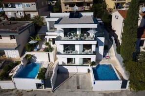 A modern two-story house with a rooftop pool and a second-floor balcony. - Villa with pool and sea view (Pješćana Uvala)