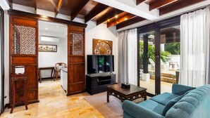 A modern living room with a sofa, a TV, and wooden decor. - Sclass Pool Villa, City area and airport (.)