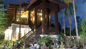 A wooden structure with a balcony, surrounded by tropical plants and palm trees. - Sclass Pool Villa, City area and airport (.)