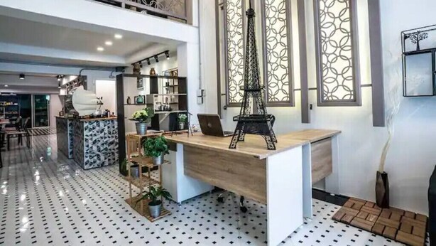 Un espacio de oficina moderno con un escritorio de madera, estanterías y objetos decorativos.