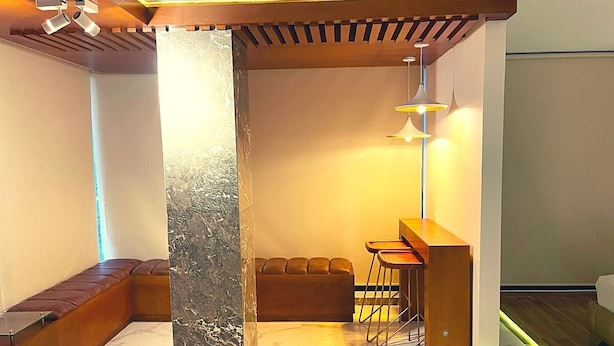 A modern interior with a seating area, a bar, and a column. - Calle 76 Apto 3 by Caribecheap (Barranquilla)