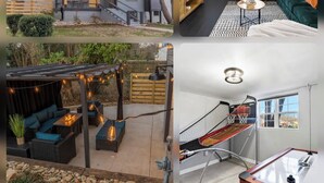 A modern house with a grey exterior, a wooden deck, and a backyard with outdoor seating and a fire pit. - Cozy 4Bd Bungalow w/ Private Backyard Lounge and Game Room Mins to Downtown (Raleigh)
