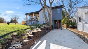 A modern two-story house with a stone retaining wall and a concrete driveway. - Cozy 4Bd Bungalow w/ Private Backyard Lounge and Game Room Mins to Downtown (Raleigh)