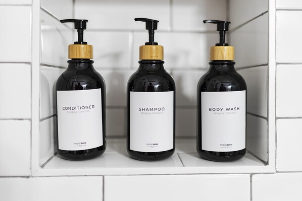 Tres botellas de productos para el cuidado de la piel sobre una estantería.