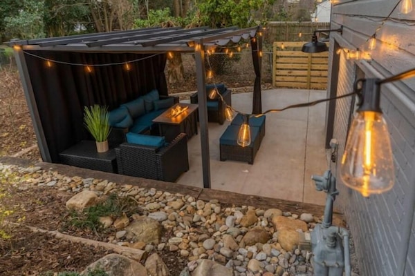 Spend a beautiful night in the backyard under this cozy pergola with a fire pit!