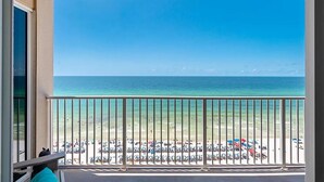 A balcony with a view of a beach and ocean.