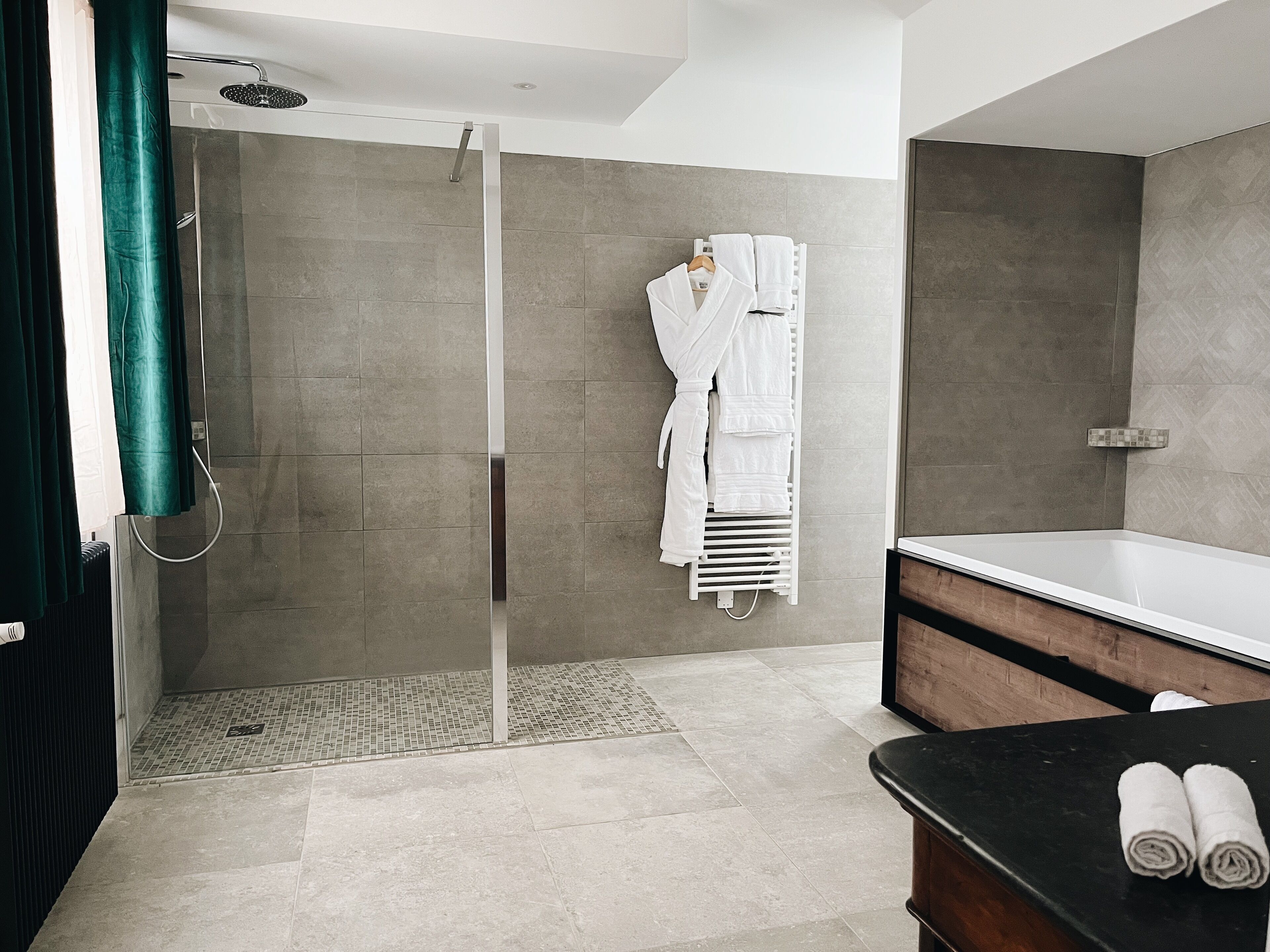 Une salle de bain moderne équipée d’une douche, d’une baignoire et d’un meuble-lavabo.
