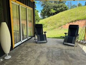 Relax in a tranquil outdoor space with two lounge chairs and a serene view.