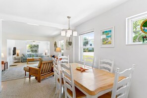 Relax in this spacious living area with a dining table for four, sofa, and TV.