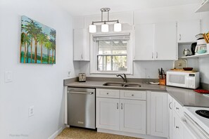 Enjoy cooking in this well-equipped kitchen with a stainless steel dishwasher and ample natural light.
