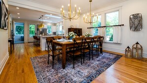 A spacious dining area with a large wooden table, multiple chairs, and a patterned rug. - 2027 OPEN! Union Pier Home With Pool and Hot Tub! Close To Private Beach! (Union Pier)
