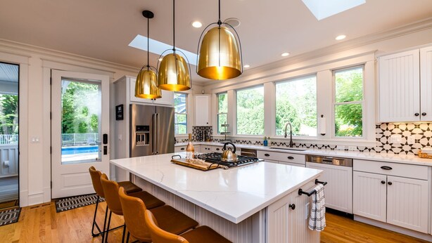 A modern kitchen with a large island, pendant lighting, and a view of the outdoors. - 2027 OPEN! Union Pier Home With Pool and Hot Tub! Close To Private Beach! (Union Pier)