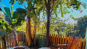 Una terraza de madera con un hogar para fuego, asientos al aire libre y vistas a un jardín exuberante.