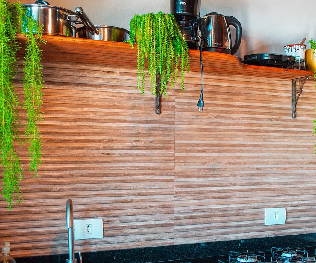 A kitchen with wooden cabinets, stainless steel appliances, and hanging plants.