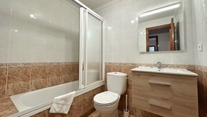 Un baño moderno con bañera, inodoro y tocador.
