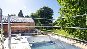 A swimming pool with a wooden deck, a pergola, and a wooden building in the background. - Longlands Farm Cottage (Grange-over-Sands)