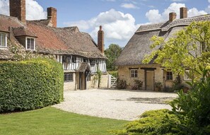 A traditional English village with thatched-roof cottages, a gravel driveway, and well-maintained hedges. - The Old Manor House  (Shipston on Stour)