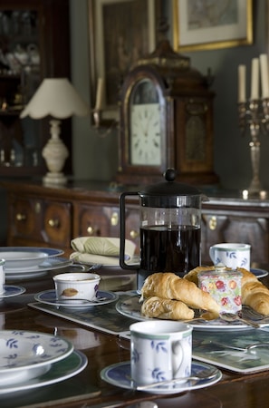 A dining table with plates, cups, a coffee pot, and pastries. - The Old Manor House  (Shipston on Stour)
