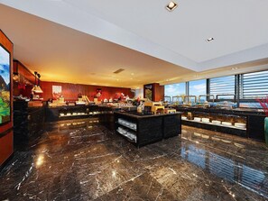 Een hotel lobby met een marmeren vloer, een receptiebalie en een groot raam met uitzicht.