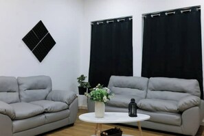 Relax in this stylish living room with two sofas, a coffee table, and a potted plant.