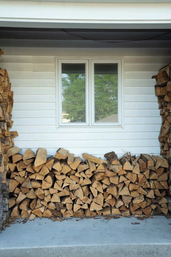 Ein Haus mit einem Fenster und einem Holzstapel an der Wand.