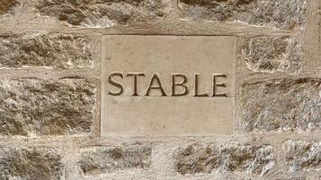 A stone wall with the word "STABLE" carved into it.
