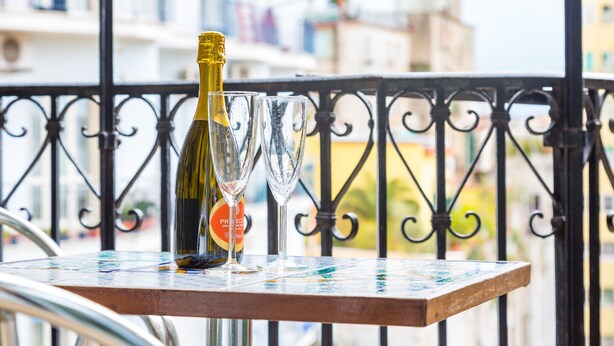 Una bottiglia di champagne e due bicchieri su una ringhiera da balcone.