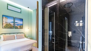 Une chambre d’hôtel avec un lit, une douche dotée d’une porte en verre et deux tableaux encadrés au mur.