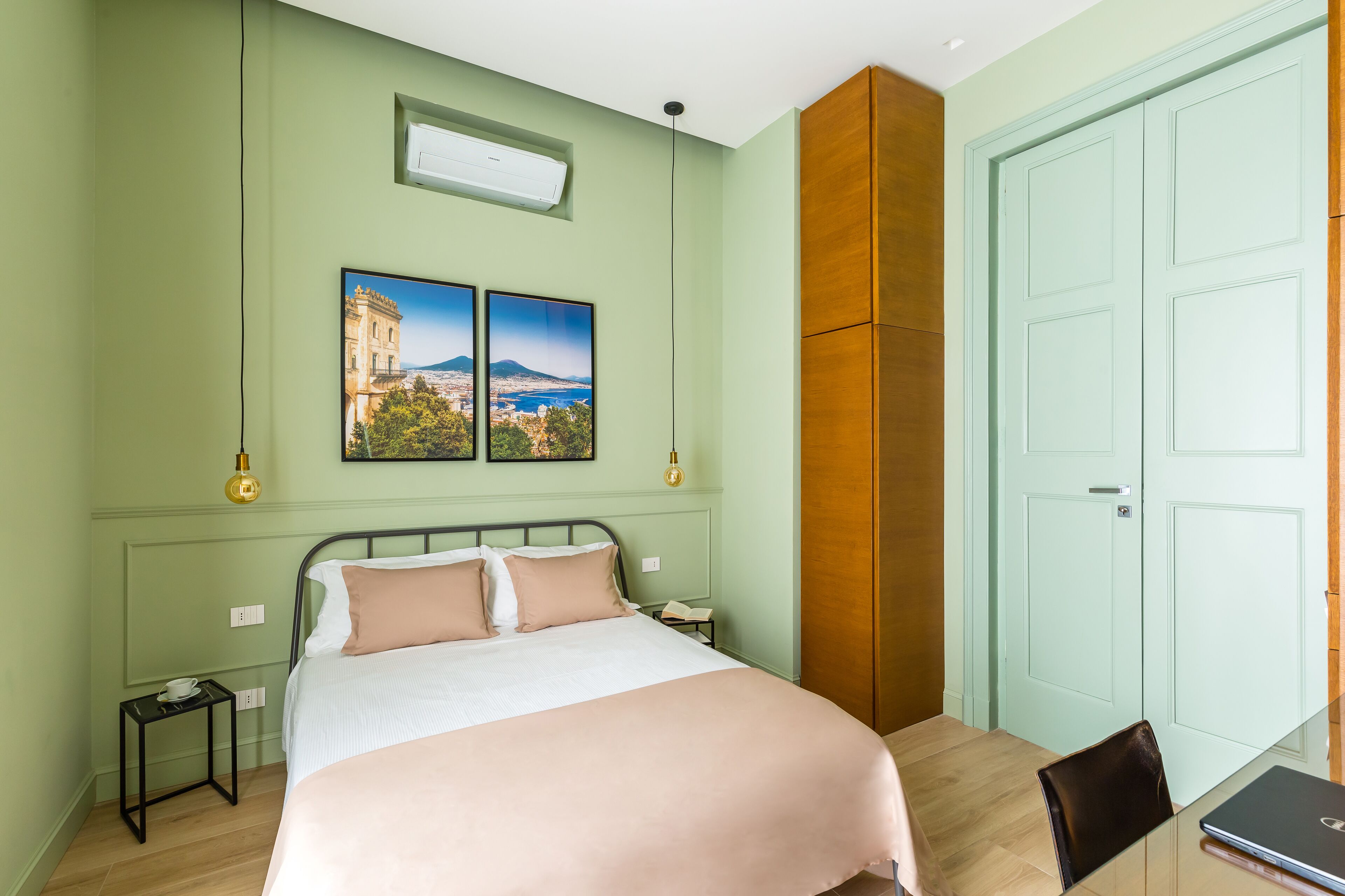 Une chambre à coucher avec un lit, une table de chevet, un bureau et une porte.