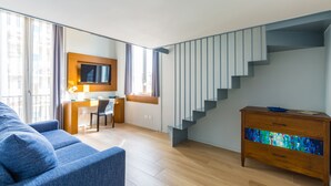 A modern living room with a sofa, a wooden dresser, and a staircase. - B&B Civico 33 - Parthenope Qdpl (Napoli)