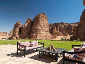 A patio with outdoor furniture and a fire pit, set against a backdrop of rock formations. - Shaden Resort Al Ula, Managed by Accor (Al-'Ula)