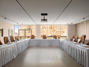 A conference room with a long table, chairs, and a large window with a view of rocky terrain. - Shaden Resort Al Ula, Managed by Accor (Al-'Ula)