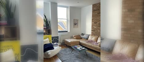Un salon moderne avec un canapé en cuir, une table basse et un mur décoratif en briques.