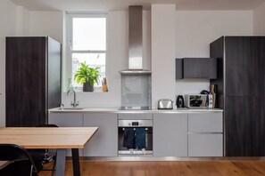 Una cocina moderna con horno empotrado, microondas y pileta.