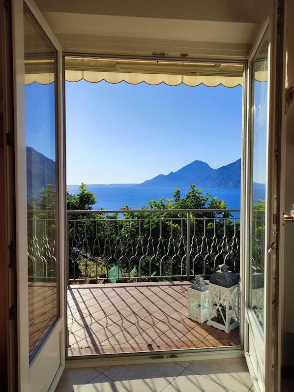 A balcony with a view of the sea and mountains.