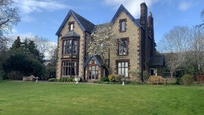 A large, historic building with a symmetrical facade, multiple windows, and a prominent chimney. - Lonsdale Villa Retreat (Penrith)