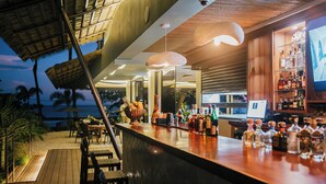 A bar area with a wooden deck, seating, and a view of the ocean. - Miamar (Quepos)