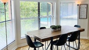 A dining area with a wooden table, black chairs, and a potted plant. - Shady Oaks Estate near Tampa (Brandon)