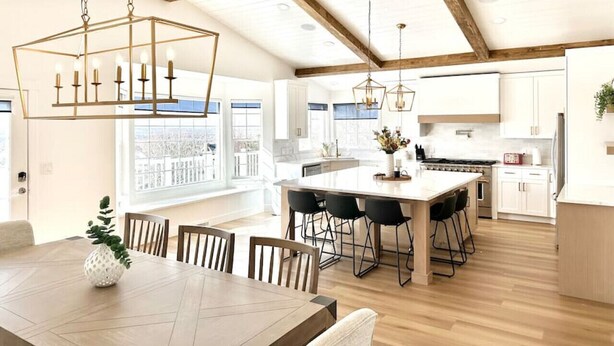 A modern kitchen with a large island, wooden beams, and pendant lighting. - Luxury Retreat with Spectacular Views (Draper)