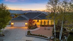 A two-story house with a garage, a landscaped front yard, and a view of mountains in the background. - Luxury Retreat with Spectacular Views (Draper)