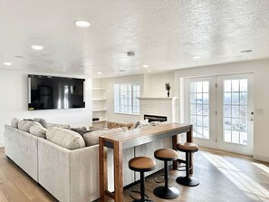 Relax in this spacious living area with a large sofa, flat-screen TV, and dining table for four.