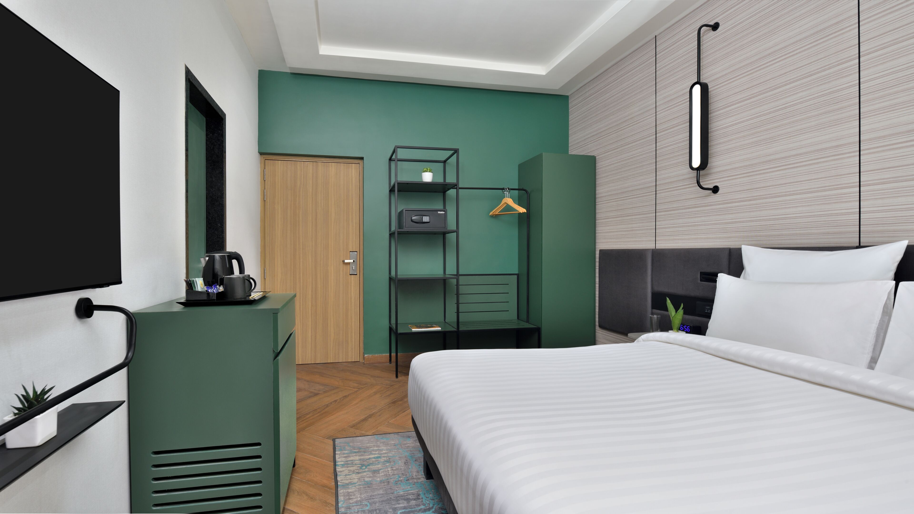 Una habitación de hotel moderna con cama, escritorio, armario y televisión.