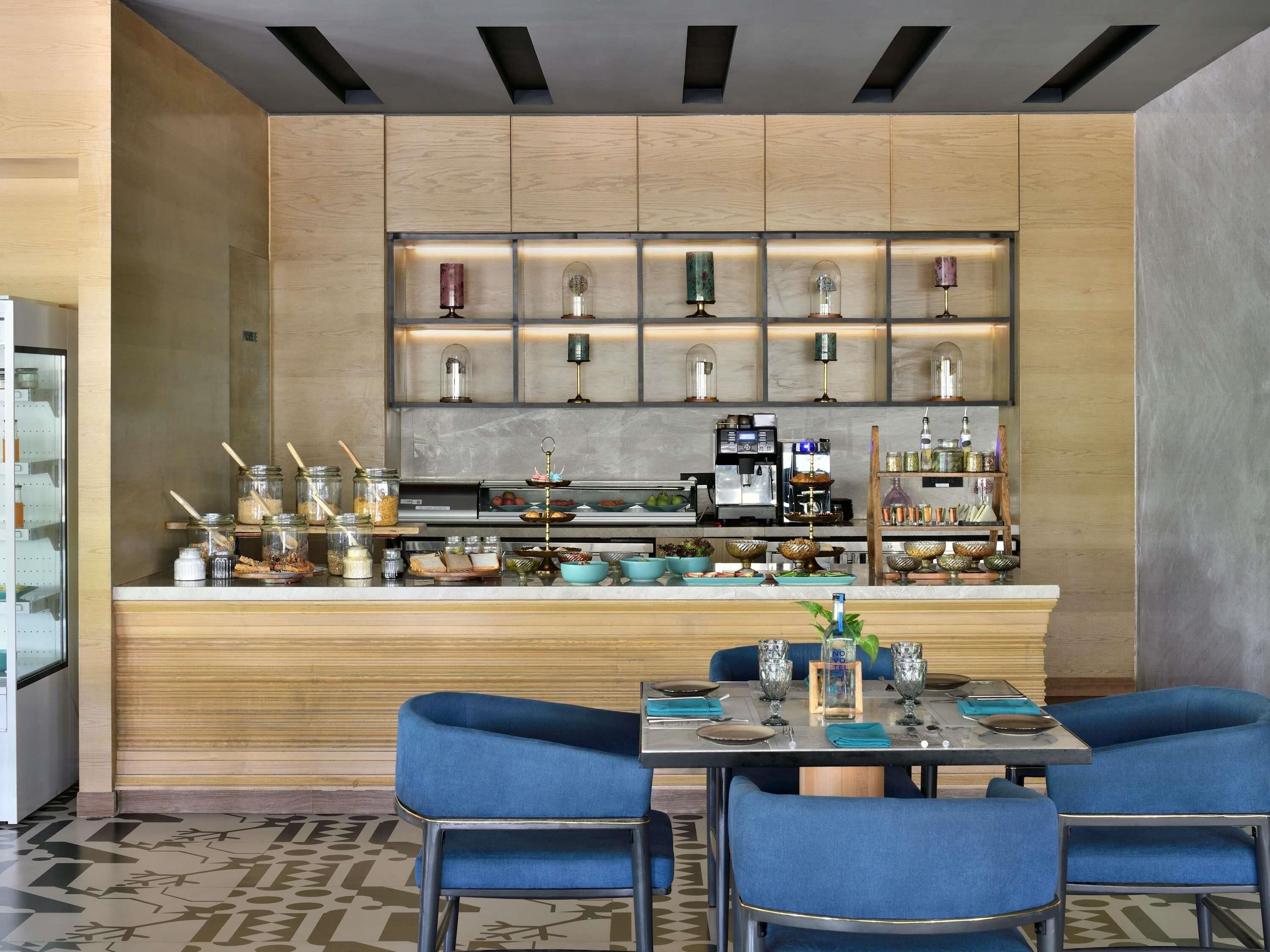 Zona de bar moderna con mostrador, asientos y diversos utensilios.