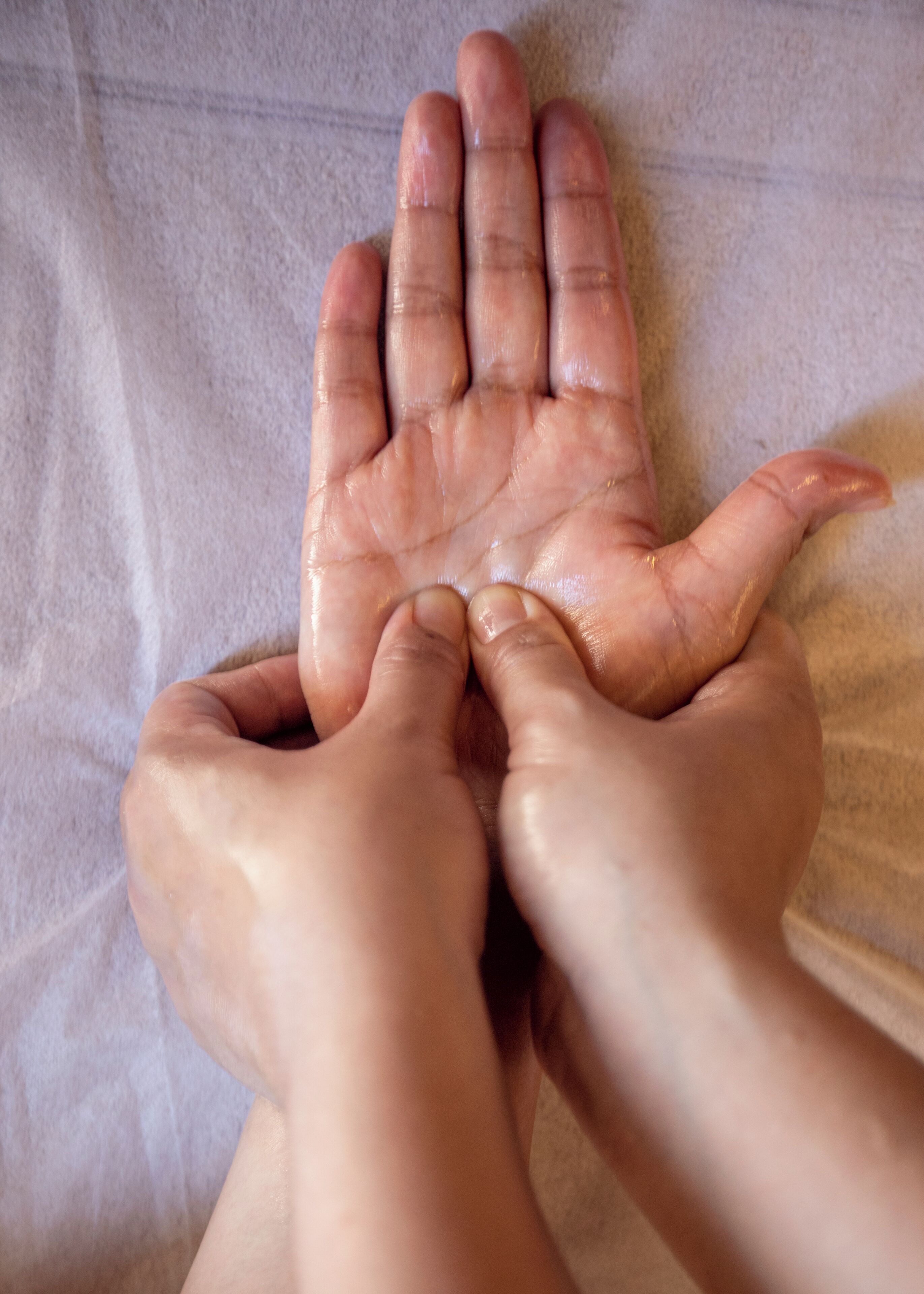 Hands resting on a textured surface, possibly a table or countertop.