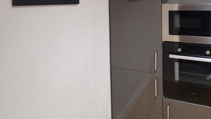 A modern kitchen with a stainless steel refrigerator, a microwave, and a double oven.