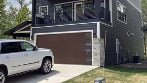 Ein modernes, zweistöckiges Haus mit Garage, überdachter Veranda und Auffahrt.