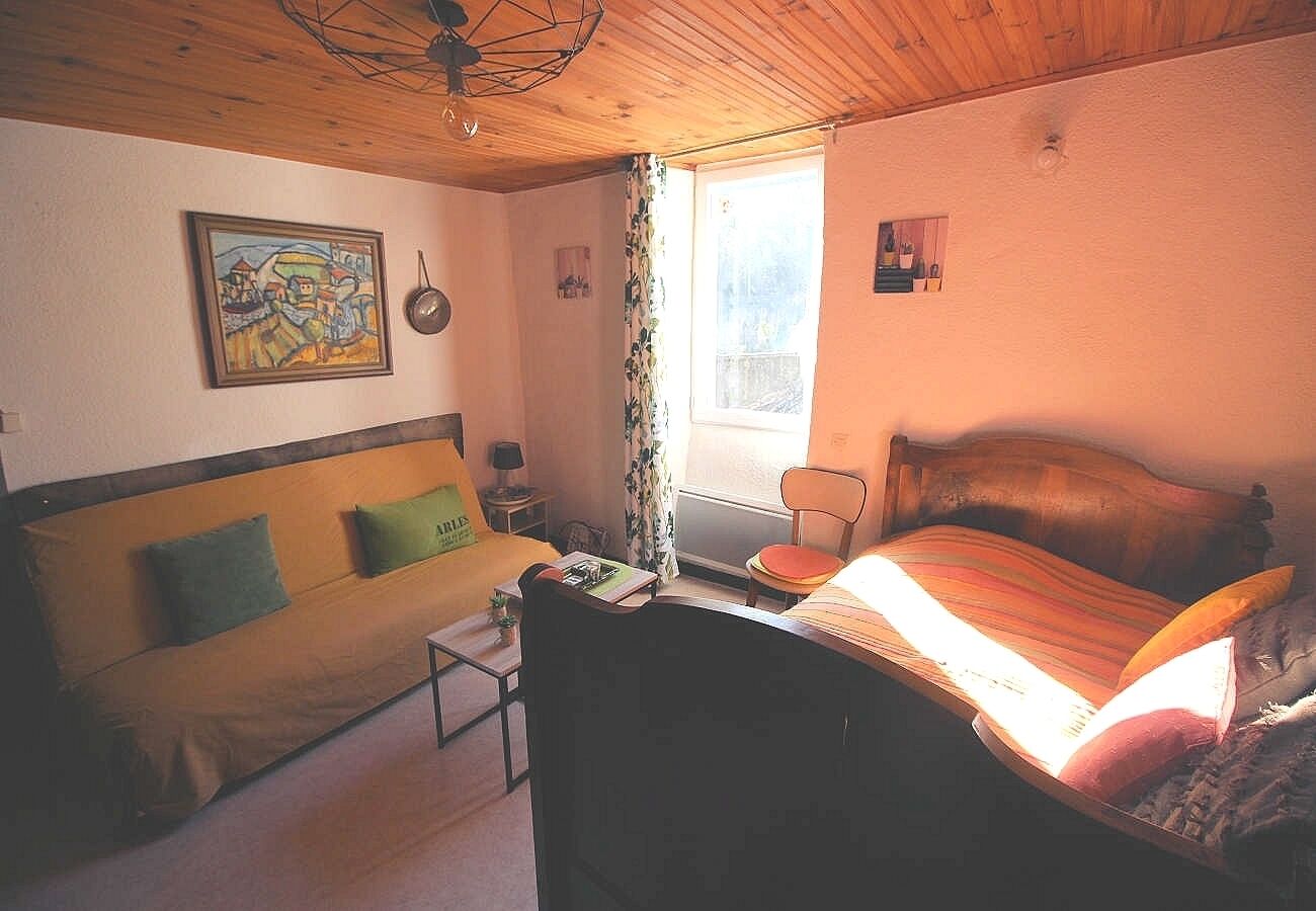 Ein Zimmer mit einem Bett, einer Couch, einem kleinen Tisch und einem Fenster mit Vorhängen.