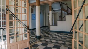 A hallway with checkered flooring, a staircase, and a decorative door with glass panels. - Bright, quiet apartment in the heart of Biarritz (Biarritz)