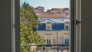 A view from a balcony with a metal railing, overlooking a building with a blue roof and a tree in the foreground. - Bright, quiet apartment in the heart of Biarritz (Biarritz)